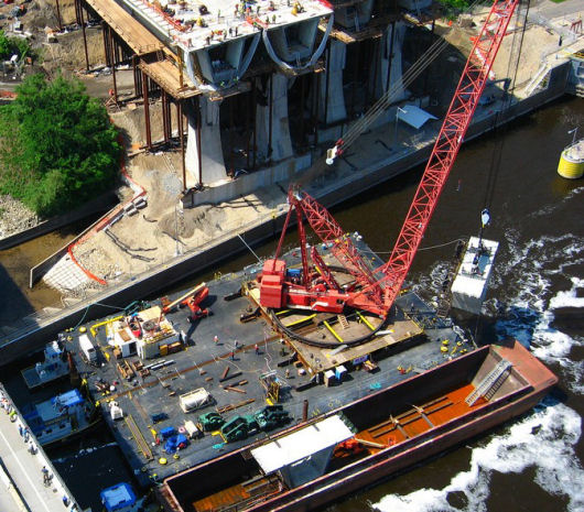 Crane barge lifting concrete bridge section